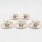 Porcelana Real, Mauá - SP(Fundada em 1943 por Fritz Erwin Schmidt). Conjunto de xícara para café em porcelana nacional da década de 1950/60; esmaltação vítrea de tonalidade branca, bojo oval com alça lateral em voluta; decoração composta por reserva oval com cena galante de tradição rococó, representando casal em paisagem, associadas a ramagens florais esparsas aplicadas em estampagem policromada; bordas e alça recobertos por generosa douração. Marca da manufatura no verso. Medidas: Xícara: Alt.: 5 x Comp.: 7,5 x Larg.: 6 cm; Pires: Diam.: 11 cm.