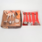 Conjunto para cozinha composto por quatro(04) utensílios em metal inoxidável, incluindo concha, colher, garfo e escumadeira, com cabos metálicos, acondicionado em estojo original identificado Backer  Vanguarda. Estado conforme fotografias. Medidas: