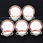 Porcelana Renner, Porto Alegre - RS(Fundada em 1937). Conjunto de xícaras para consommé em porcelana nacional, estilo Art Déco; esmaltação branca, decorada com faixa de tom bordõ, sobreposta por frisos vegetalistas em douradura, bojo aproximadamente obcônico, alças laterais em voluta, padrão decorativo replicado no pires. Marca da manufatura no verso. Medidas: