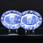 Wood & Sons, Burslem - Inglaterra(Fundada em 1865). Duas(02) travessas ovais em faiança inglesa da década de 1920. Esmaltagem vítrea na cor branca, profusa decoração na técnica "blue and white", intitulada 'English Scenery', com paisagem campestre contendo casario, personagens e igreja ao fundo, orla circundada por flores e folhagens, borda contornada por friso na tonalidade cobalto. Marca da manufatura no verso. Medidas.: Comp.: x Larg.: