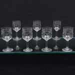 Conjunto de taças em cristal francês, diáfano e incolor, para licor; bojo lavrado com faixa torcida suspendendo guirlanda de flores e laçarotes, fuste cilíndrico sobre base circular. Composto de sete(07) unidades. Medidas: Alt.: 11 x Diam.: 4,5 cm.
