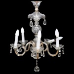 Lustre de seis luzes em cristal e vidro, translúcido, com estrutura composta por hastes curvas, corpo central moldado e elementos pendentes em cristal lapidado; braços simétricos, bocais em forma de tulipa com pingentes prismáticos, prato superior recortado com pendentes e elemento terminal inferior em forma de gota facetada. Apresenta perda de pingentes, quebraduras e marcas do tempo. Medidas: Alt.: x Diam.: