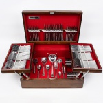 MERIDIONAL. Belíssimo faqueiro acondicionado em caixa original, interior revestido em tecido de tom bordô, contendo duas bandejas retráteis e fundo com molde para encaixe das peças; talheres confeccionados em aço inox, cabo de borda contornada por fileira perlada em relevo. Composto de cento e trinta(130) peças.