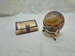 Lote de caixa decorativa em osso com acabamento em metal e bola decorativa em vidro de murano com suporte em metal com pés de osso. Medindo a caixa 10,5cm x 7,5cm x 4,5cm de altura.