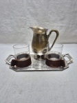 Bandeja retangular com pequena jarra em prata 90 e 2 copos em vidro com suporte em madeira. Medindo a bandeja 28cm x 19,5cm x 35cm alça alça.