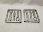 Par de descansos de panela em alumínio na forma de talheres. Medindo 18,5cm x 18,5cm.