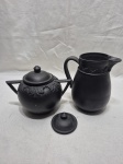 Lote de jarra e açucareiro em cerâmica com patina preta. Medindo a jarra 16cm de altura. Tampa do açucareiro com leves bicados.