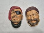Par de placas decorativas em gesso assinado Mastroperu, representando piratas. Medindo o maior 15cm de comprimento.