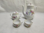 Jogo de bule, açucareiro e 2 xícaras de café sem pires em porcelana Pozzani canelada com flores e friso ouro.  Medindo o bule 15cm de altura.