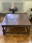 Mesa de centro em madeira, com tampo quadrado e pernas torneadas interligadas por travessa inferior. Altura: 46cm. Medidas do tampo: 108x108cm. Apresenta sinais compatíveis com o tempo e uso.