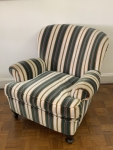 Poltrona estofada em tecido listrado tipo veludo, com encosto levemente curvo e braços arredondados. Assento amplo e pés em madeira. Medidas: 80cm de altura, 82cm de largura e 62cm de profundidade. Apresenta sinais compatíveis com o tempo e uso.