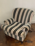 Poltrona estofada em tecido listrado tipo veludo, com encosto levemente curvo e braços arredondados. Assento amplo e pés em madeira. Medidas: 80cm de altura, 82cm de largura e 62cm de profundidade. Apresenta sinais compatíveis com o tempo e uso.