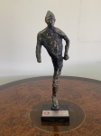 "Waldomiro Motta, escultura em bronze sobre base de granito preto representando o mascote Saci. (37cm alt). Apresenta placa comemorativa dos 93 anos do Sport Club Internacional - 04/04/2002. Acompanha título de ""Honra ao Mérito"" de 09/1976 e Diploma de Conselheiro concedidos ao Dr. Oswaldo de Lia Pires."