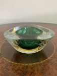 Cinzeiro em cristal de Murano na tonalidade verde formando constraste cromático. Apresenta pequenos bicados na borda mas que não compromete a peça. Largura 15cm. Altura 7cm.