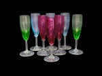 Cristallerie Saint Louis (Saint-Louis-lès-Bitche, Lorraine, França, 1586), oito (8) taças flutes confeccionadas em cristal francês de tonalidades distintas, lapidadas por gregas e guirlandas florais, haste cilíndrica apoiada sobre base circular, medindo 18x4cm.