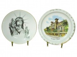 PORCELANAS, dois (2) pratos decorativos souvenir, sendo: A) um (1) prato com ilustração da Estátua da Liberdade (New York), com filete dourado na borda, medindo 22cm (falhas na douração) e B) COIMBRA, um (1) prato com ilustração arquitetônica e inscrição SAN REMO  IL CASINO, com decoração na borda, medindo 23cm, falhas na douração.