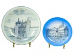 PORCELANAS, dois (2) pratos decorativos confeccionadas em porcelana branca em tom azul/cinza, sendo: A) um (1) prato com ilustração arquitetônica e inscrição VISEU  Portugal, medindo 23,5cm e B) B&G, um (1) prato menor em azul, com desenho de paisagem urbana/ribeirinha, medindo 18cm.