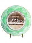 PORCELANA REAL, um (1) prato decorativo confeccionado em porcelana nacional na tonalidade branca, faixa verde com elementos florais na cor branca, centro representando Santa Ceia com filetes e arremates em ouro, medindo 24cm.
