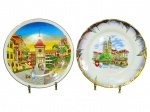 PORCELANAS, dois (2) pratos decorativos souvenir (Suíça) confeccionados em porcelana branca, sendo: A) um (1) prato com ilustração de cidade alpina, em policromia, com símbolos da bandeira suíça, medindo 25cm e B) um (1) prato com borda recortada e dourada, decoração com vista de Zürich  Grossmünster e escudos, medindo 25cm.