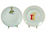PORCELANAS, dois (2) pratos decorativos em porcelana branca, tema Cristo Redentor/Rio de Janeiro, sendo: A) um (1) prato com ilustração do Cristo e inscrição Lembrança do Corcovado  Rio de Janeiro, com filete na borda, medindo 24cm bicado na borda e B) um (1) prato com duas silhuetas do Cristo e inscrição Cristo Redentor, com filetes na borda, medindo 25cm.