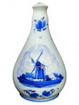 PORCELANA DELFT, uma (1) jarra confeccionada em porcelana na tonalidade branca, decorada por paisagem holandesa com moinho e elementos vegetalistas na tonalidade azul, medindo 20,5cm de altura.