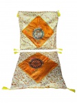 CAMA, MESA & BANHO, conjunto com duas (2) capas de almofada em tecido tipo brocado/sedoso, com padronagem floral e aplicação central em losango na cor laranja, com detalhe circular ao centro, acabamento com pingentes/franjas nos cantos, medindo 40x40cm.