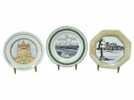 PORCELANAS, três (3) pratos decorativos confeccionados em porcelana na tonalidade branca, sendo: A) um (1) prato com ilustração do Santuário de Santa Luzia (Viana do Castelo), com filetes na borda, medindo 19cm, B) um (1) prato com cena em preto e branco e inscrição Fleming, borda com ornamentos em verde/dourado, medindo 21cm; e C) um (1) prato octogonal com decoração em preto e branco, tema Ruínas de São Miguel  RS  Brasil, com craquelê/douração na borda, medindo 19x19cm, bicado na borda.