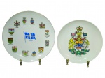 PORCELANAS, dois (2) pratos decorativos confeccionados em porcelana na tonalidade branca, sendo: A) um (1) prato com bandeira de Quebec ao centro e escudos das províncias/territórios ao redor, medindo 24cm e B) um (1) prato com brasão do Canadá ao centro e inscrição CANADA, medindo 21cm.
