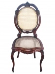 MOBILIARIO, uma (1) cadeira medalhão, confeccionada em madeira escura, com encosto oval e assento em palhinha sintética, espaldar com vazados, saia recortada e pernas curvas de desenho elegante e inspiração clássica, medindo 104x49,5x49cm.