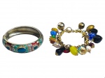 BIJUTERIAS, lote com duas (2) peças, sendo: A) 1 bracelete com rica esmaltagem em cloisonné com elementos geométricos relevados e incrustação de pedrarias sintéticas, medindo 7,5cm de diâmetro, leves sinais de oxidação e B) 1 pulseira em metal dourado com pendantes sintéticos e em vidro de modelos, tamanhos e decorações distintas, apresentando sinais de uso, medindo 19cm de comprimento.