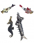 BIJUTERIAS, lote quatro (4) pingentes de modelos, tamanhos, decorações e materiais distintos, sendo: A) 2 representando peixe em vidro de Murano, medindo 3,5cm, B) 1 representando cavalo marinho em metal dourado, 4cm e C) 1 representando sereia em metal espessurado a prata, medindo 5,5cm de comprimento.
