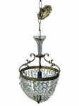 LUSTRE, um (1) lustre para uma lâmpada confeccionado em bronze com decoração em pendantes de cristal facetado, hastes no feitio de arabesco, parte superior em cristal com pequeno bicado na borda, parte inferior finalizada em pinha, acompanha canopla, 1 fio de pendante solto, medindo até a canopla 80cm de altura e 30 cm de diâmetro.