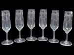 Cristallerie Saint Louis (Saint-Louis-lès-Bitche, Lorraine, França, 1586), seis (6) taças flutes confeccionadas em cristal francês translucido com lapidação de guirlanda floral e laçarote em baixo relevo, haste cilíndrica apoiada sobre base circular, 1 apresenta bicado na borda, medindo 17,5x4cm.