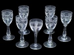 Cristallerie Saint Louis (Saint-Louis-lès-Bitche, Lorraine, França, 1586), sete (7) taças para licorconfeccionadas em cristal francês translucido, sendo 6 com lapidação de guirlanda floral e laçarote em baixo relevo,  e 1 com ramos de flores e guirlanda geométrica, ambos modelos com haste cilíndrica apoiada sobre base circular, medindo 9,5x3,5cm e outra 8,5x3,5cm.