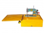 DIVERSOS, uma (1) máquina de costura portátil da manufatura BAMBI, confeccionado em metal com esmaltagem verde e colagens florais, acondicionada em caixa de madeira clara, funcionando e em ótimo estado de conservação, medindo 8,5x21x19,5cm.