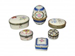 PORCELANAS, seis (6) caixinhas confeccionadas em porcelana na tonalidade branca de modelos, tamanhos e decorações distintas, maior medindo 7,5x5,5cm (borda colada) e menor 2,5x3,5cm. 1 apresenta sinais de oxidação.