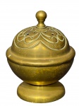 METAL DOURADO, um (1) incensário confeccionado em metal dourado com cinzelado de elementos vegetalistas e pega da tampa no feitio de bilro, apresenta ínfimas mossas na borda e sinal de solda na lateral, possivelmente levava uma alça, medindo 8,5x6,5cm.