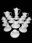 PORCELANA SCHMIDT, serviço para chá/café confeccionado em porcelana nacional na tonalidade branca, decorado por elementos florais em monocromia com realces brancos e borda filetada em prata, sendo: A) 1 bule para café, medindo 20x17x8,5cm, B) 1 bule para chá, medindo 17x20x11cm, C) 1 leiteira, medindo 13x15x8,5cm, D) 9 xícaras para café com seus respectivos pires 1 com ínfimo bicado na borda, medindo 5x7x5cm e C) 6 xícaras para chá com seus respectivos pires, medindo 7x10x8cm;