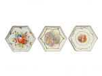 PORCELANA REAL, três (3) porta copos sextavados confeccionados em porcelana nacional na tonalidade branca, 2 decorados por cenas ninfas em policromia e 1 com elementos florais em policromia, todos com filetes em ouro, medindo 9x9cm.