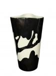 PORCELANA TEIXEIRA, um (1) vaso confeccionado em porcelana na tonalidade branca com pintura abstrata na tonalidade preta, assinado Vera, bordas em ondulações, medindo 25x14x14cm.