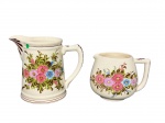 FAIANÇAS, lote com duas (2) peças confeccionadas em faiança na tonalidade creme, possivelmente Weiss, com rica decoração floral em policromia e filetes marrons, sendo; A) 1 jarra, medindo 18x21x11cm (bicado e fio de cabelo) e B) 1 leiteira, medindo 13,5x17x9cm.