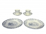 PORCELANA SCHMIDT, lote com quatro (4) peças confeccionadas em porcelana nacional na tonalidade branca decoradas por elementos florais em monocromia na tonalidade azul, sendo: A) 1 par de xícaras para café com seus respectivos pires, medindo 5,5x7,5x5,5cm e B) 2 pratos para sobremesas decorado por cena de carruagem, medindo 19,5cm.