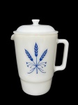 COLOREX (Em 1961, a Vidraria Santa Marina lançou um conjunto de louças), uma (1) leiteira com tampa confeccionada em vidro opalinado na tonalidade branca com decoração de trigais na tonalidade azul, medindo 19x15x11,5cm.