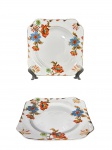 IMPERIAL NKT, dois (2) pratos para pão confeccionados em faiança japonesa na tonalidade branca, decorado por flores e folhagens em policromia, filetes e realces em ouro, sinais de craquele, medindo 15x15cm.