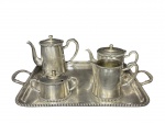 METAL PRATEADO, serviço para chá/café com cinco (5) peças, sendo: 1 bule para café, medindo 17x21x8cm, B) 1 bule para chá, medindo 13x22x10cm, C) 1 leiteira, medindo 12x16x7,5cm, D) 1 açucareiro com pequena mossa na alça, medindo 9x16,5x8cm e E) 1 bandeja retangular, medindo 53x32,5cm, confeccionados em metal espessurado a prata com borda cinzelada em gomos, apresentam falhas na prateação.