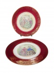 FAIANÇA IMPERIAL SALEM, dois (2) pratos decorativos confeccionados em faiança na tonalidade branca, decorado por espessa faixa na tonalidade vermelha com guirlanda floral em vasta douração, centro com pintura de damas antigas em policromia, ambos com leves marcas do tempo e falhas na douração, medindo 27,5cm.