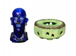ESCULTURA e FAIANÇA, lote com duas (2) peças, sendo: A) 1 escultura confeccionada em faiança vitrificada na tonalidade azul representando figura africana, medindo 18,5cm de altura e B) um (1) rechaud confeccionado em faiança com pintura acidada na tonalidade verde, decorada por elementos em vazados e borda na tonalidade marrom, marcado no fundo, medindo 7x15,5x15,5cm.