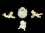 PORCELANAS, lote com quatro (4) peças, sendo: A) 1 caixa porta joias confeccionado em porcelana branca com vazados, tampa com flores e folhagens em policromia e relevo, medindo 8x7cm, B) 2 adornos de velas representando querubim confeccionados em biscuit policromado,  medindo 10cm e C) 1 escultura representando querubim confeccionado em porcelana branca, medindo 6,5x6,5x5,5cm.