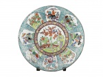 PORCELANA ORIENTAL, um (1) prato decorativo confeccionado em porcelana branca com decoração de flores, folhagens, paisagens, borboletas e pássaros em rica policromia, medindo 27cm de diâmetro.