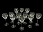 CRISTAIS, doze (12) taças para vinho confeccionadas em cristal translucido, corpo com gomo na parte inferior, haste cilíndrica apoiada sobre base circular, medindo 20x7cm. 2 bicados na borda.